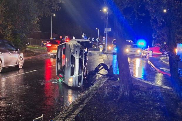 Police close road after car flips onto its side near major roundabout