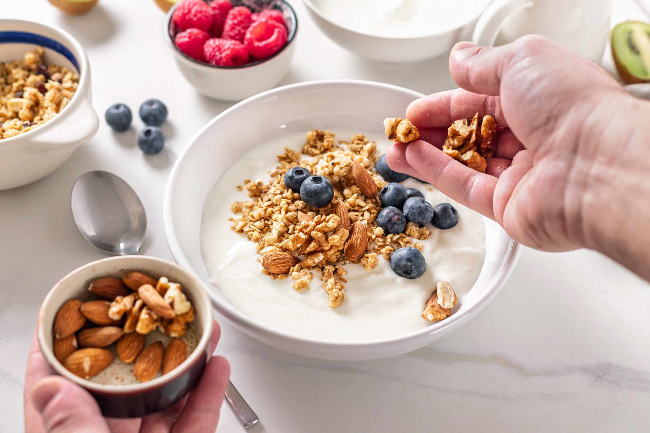Greek yogurt with granola, fresh blueberries, raspberry and almonds. A quick and healthy breakfast concept