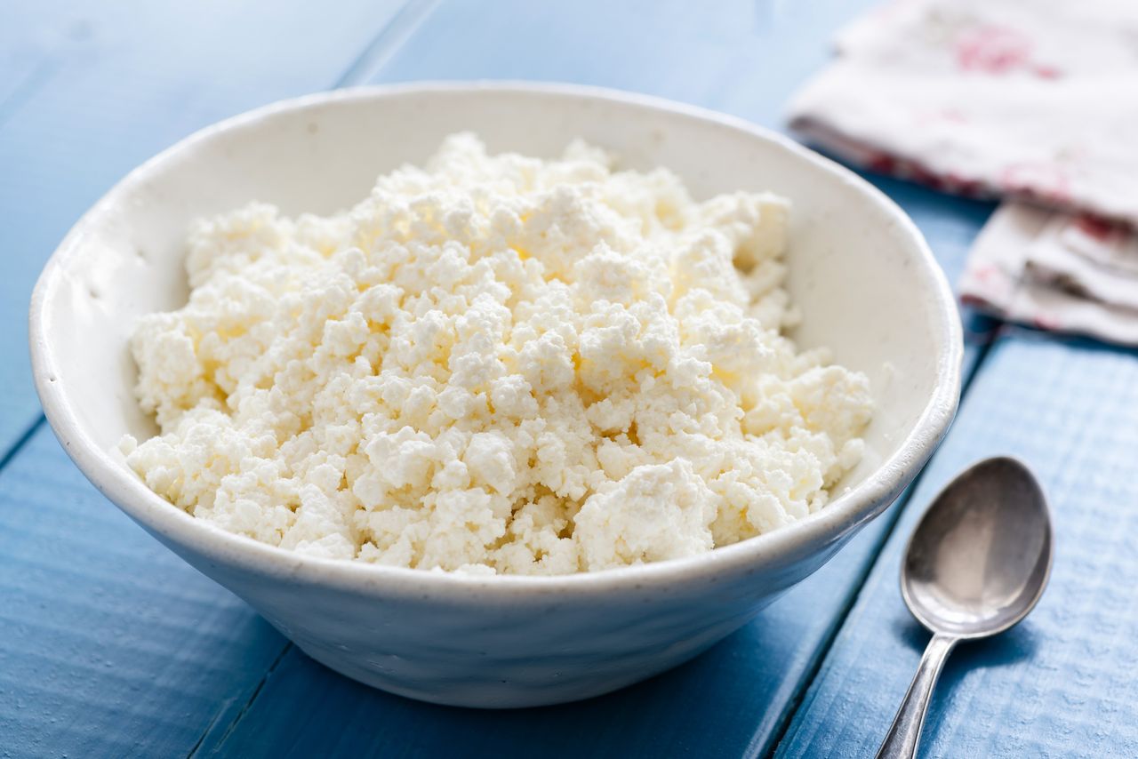 Cottage cheese in white bowl on blue table