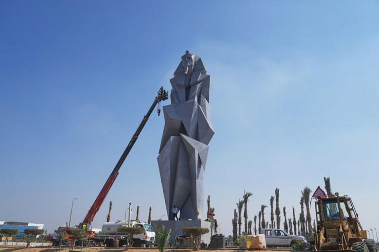 Workers paint the 27 meters (89 feet) iron statue "The guard" by Egyptian artist Deyaa Awed, which will face visitors coming from Sphinx airport to the Grand Egyptian Museum. Amr Nabil/Copyright 2025 The AP. All rights reserved