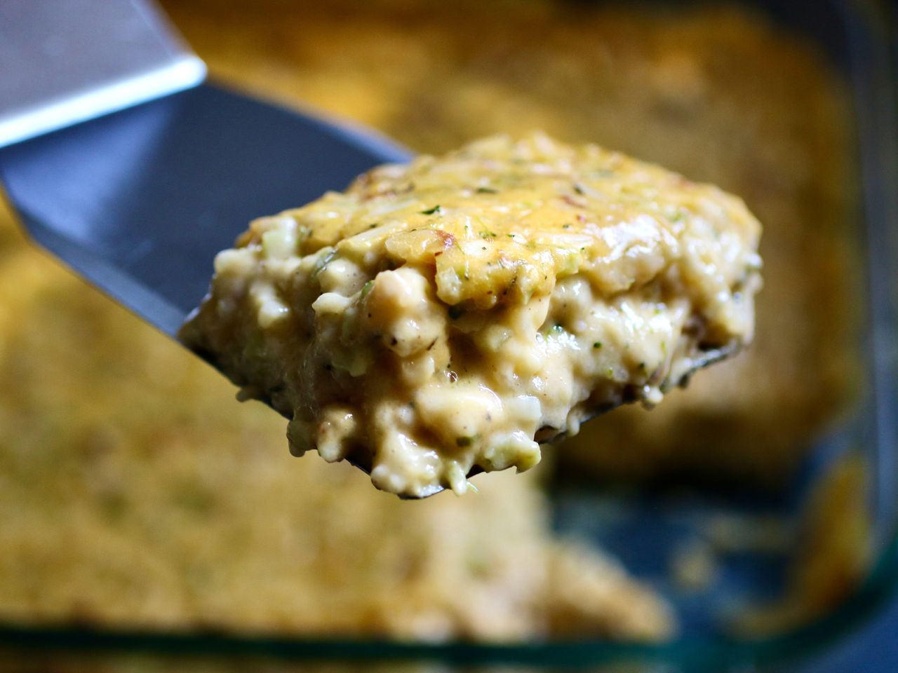 Slice of Broccoli cheese casserole on blue spatula