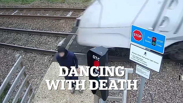 Shocking CCTV shows teen 'playing chicken' with train at level crossing