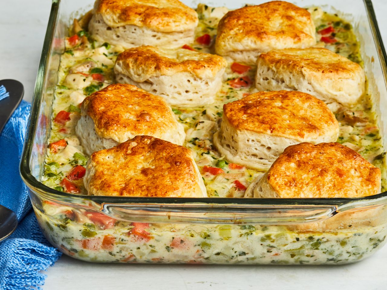mid-low view of chicken pot pie with a biscuit crust served in a casserole dish