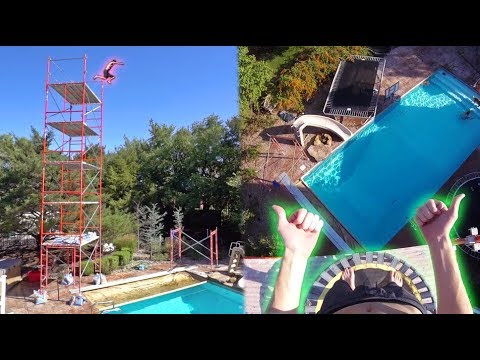 Skilled athletes jump from five story cliff onto trampoline