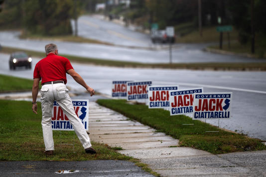 Joe Abegg, a candidate for Burlington County Commissioner, adjusts lawn signs along Route 206 before the arrival of Republican candidate for governor Jack Ciattarelli at Palermo’s Pizza in Bordentown.