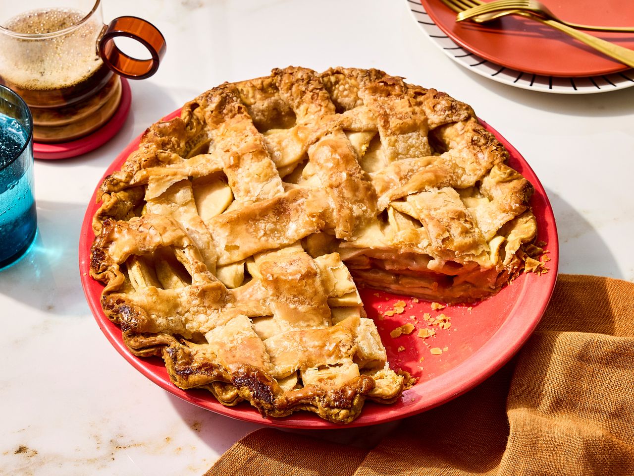Apple pie in a red pie pan.