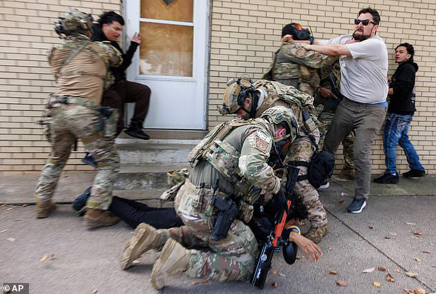 ICE agents detain a protestor as other protesters try to stop them in East Side, Chicago, Tuesday, October 14, 2025
