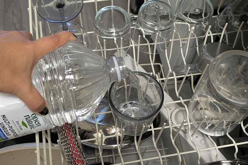 Someone pouring vinegar in glass.
