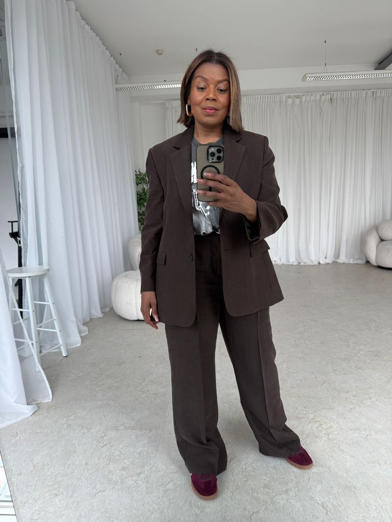 woman taking a selfie in a brown suit