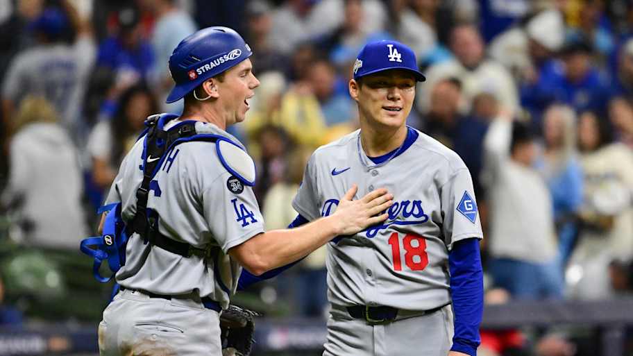 Oct 14, 2025; Milwaukee, Wisconsin, USA; Los Angeles Dodgers catcher Will Smith (16) and pitcher Yoshinobu Yamamoto (18) celebrate after defeating the Milwaukee Brewers in Game 2 of the NLCS round for the 2025 MLB playoffs at American Family Field. | Benny Sieu-Imagn Images