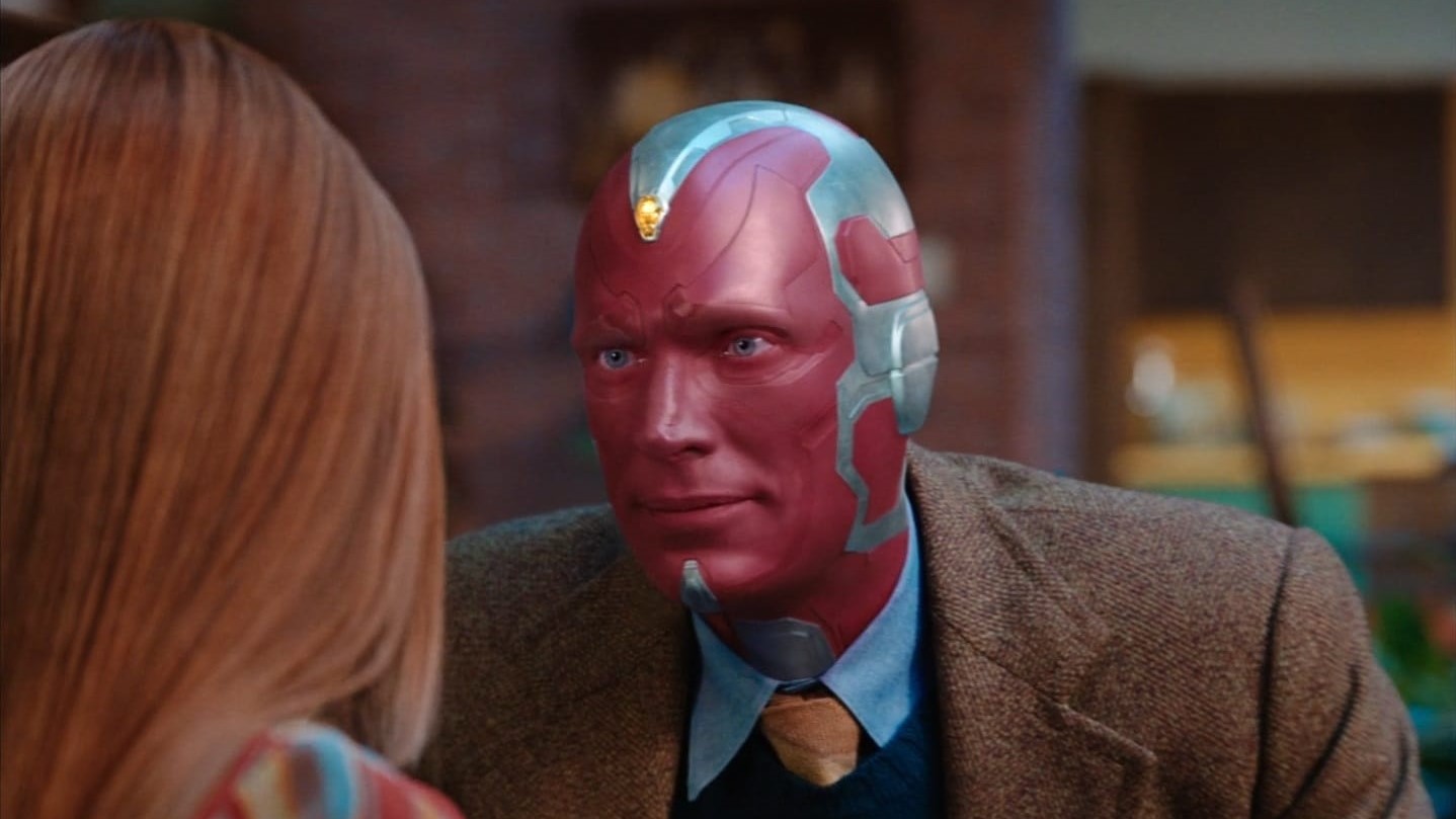 A suited Vision looking at an off-camera Wanda Maximoff in WandaVision
