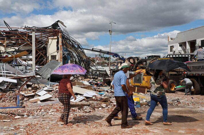 Pessoas caminham em região afetada por tornado no Paraná. Foto: Daniel Castellano/AFP