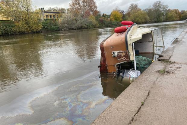 Capsized boat spilling oil into River Severn