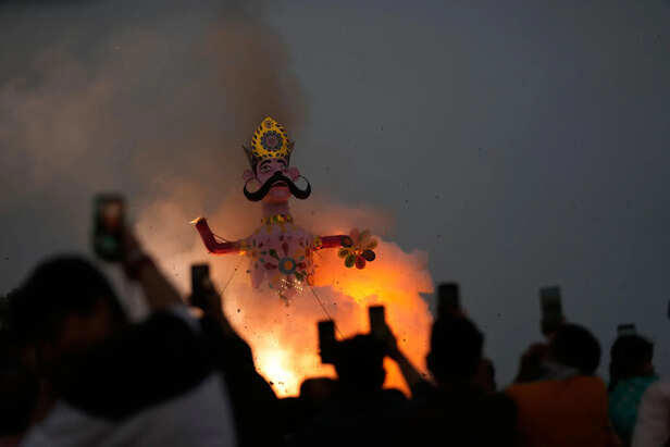 Indian people watch an effigy of demon king Ravanas son Meghnath go up in flames marking the end of Dussehra festival in Jammu, India, Thursday, Oct.2, 2025.(AP Photo/Channi Anand)