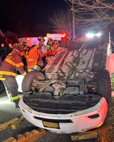 Driver trapped after hitting parked car, overturning in Sayville