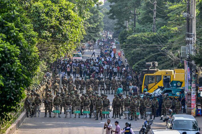 Agentes de segurança fazem a guarda enquanto manifestantes tentam demolir a residência de Sheikh Mujibur Rahman, o primeiro presidente de Bangladesh e pai da ex-primeira-ministra Sheikh Hasina, em Daca, nesta segunda-feira, 17. Foto: Munir Uz Zaman/AFP