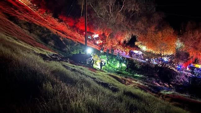 Driver rescued after Jeep rolls down large hill, crashing into power pole