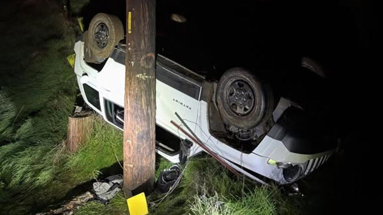 Driver rescued after Jeep rolls down large hill, crashing into power pole