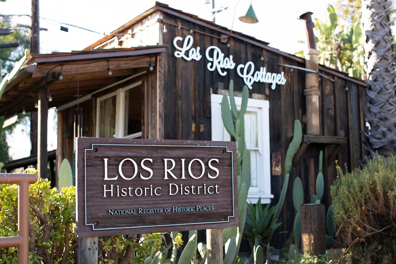 A historic building with a sign reading Los Rios Historic District and Los Rios Cottages in front