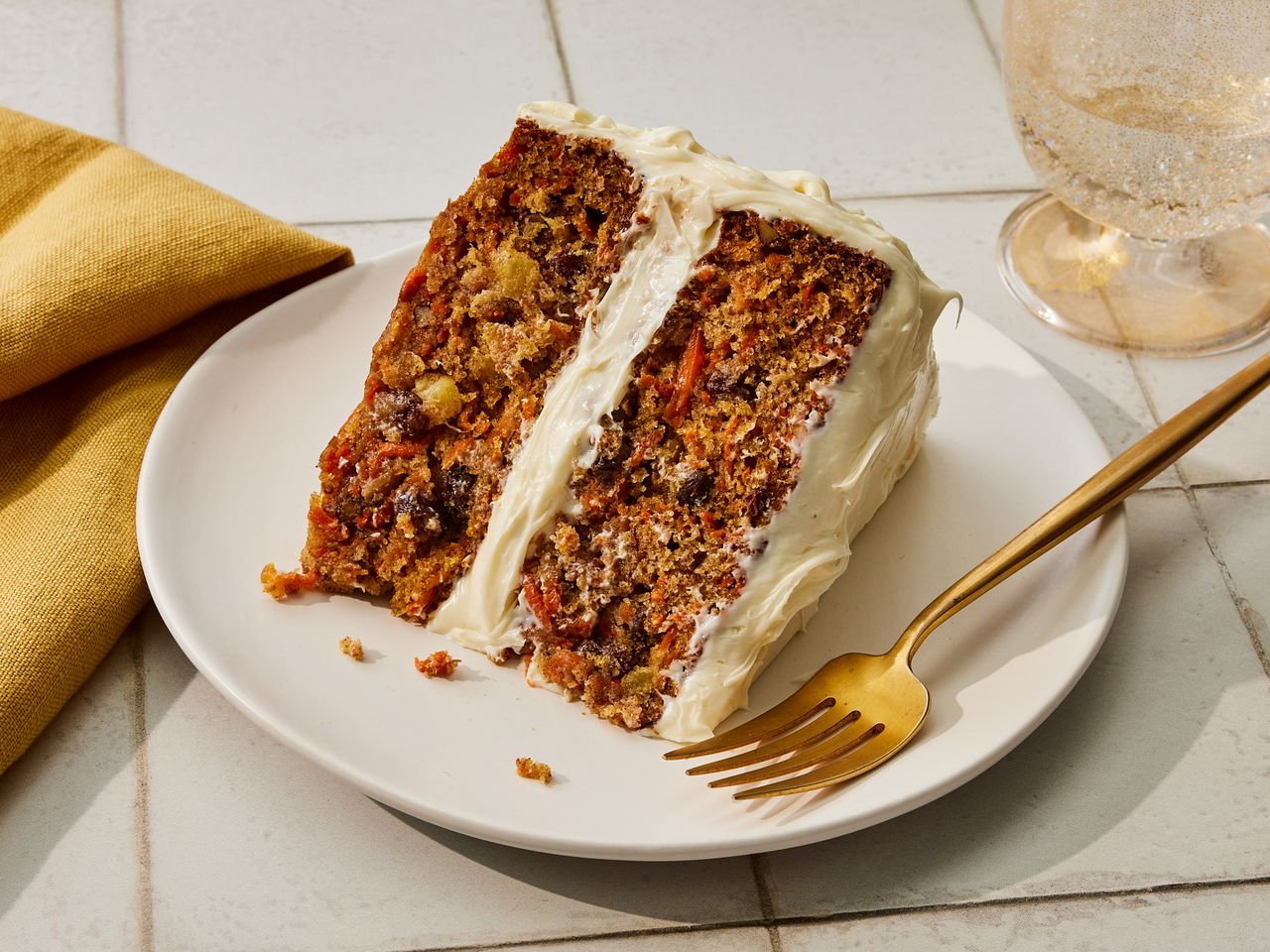 A plated slice of carrot cake with cream cheese frosting