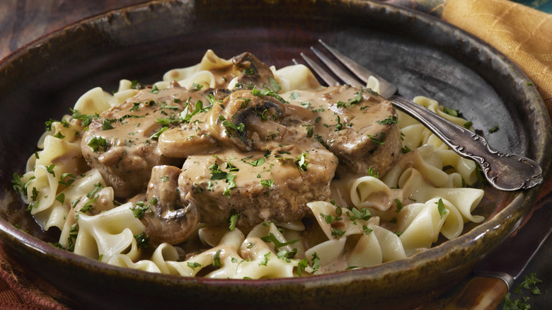 beef and noodle dish in bowl with fork