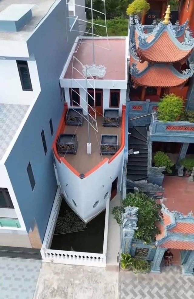 Building designed to resemble a ship's bow, with details mimicking a cruise ship, situated between modern and traditional architectural structures