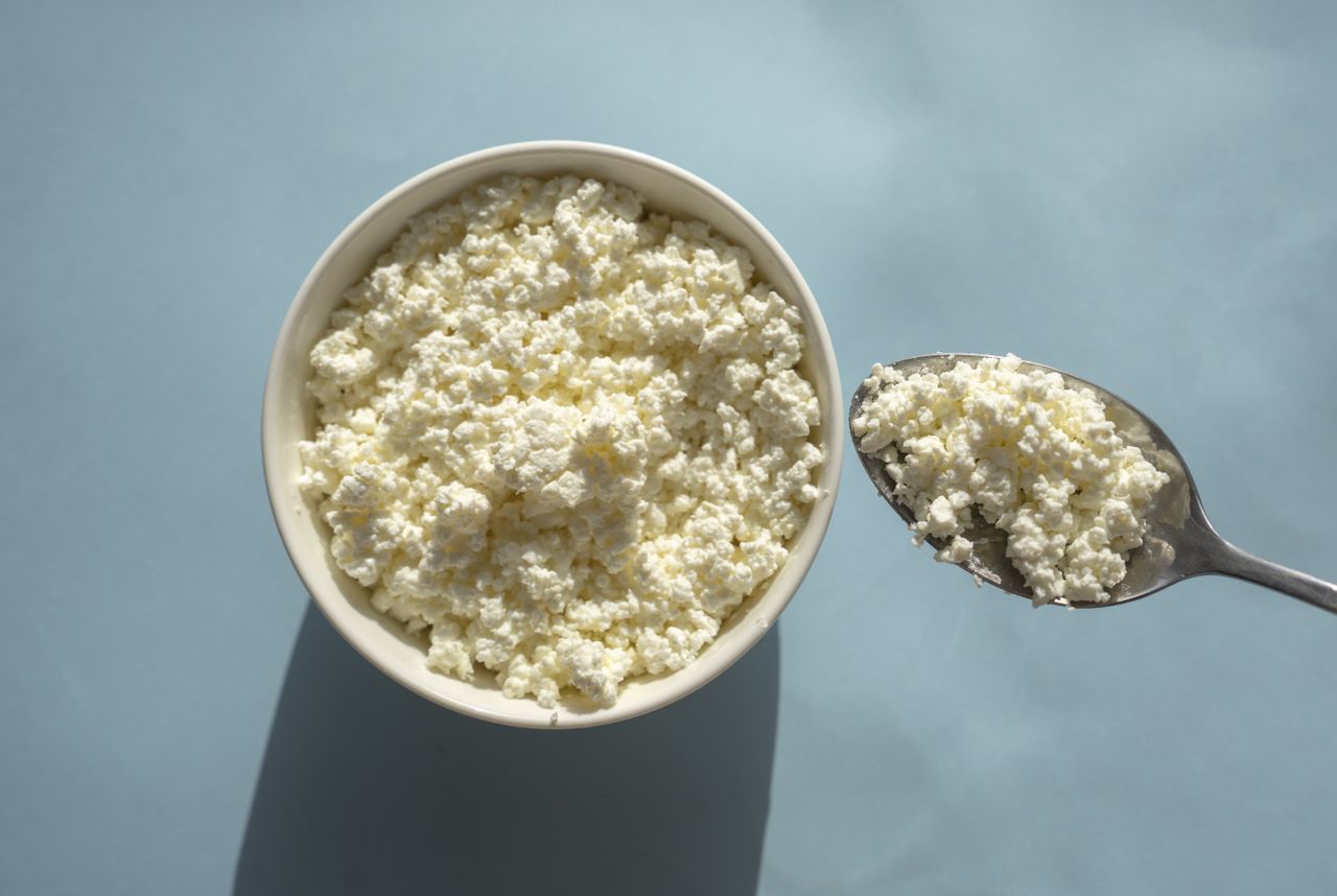Bowl and spoon containing cottage cheese