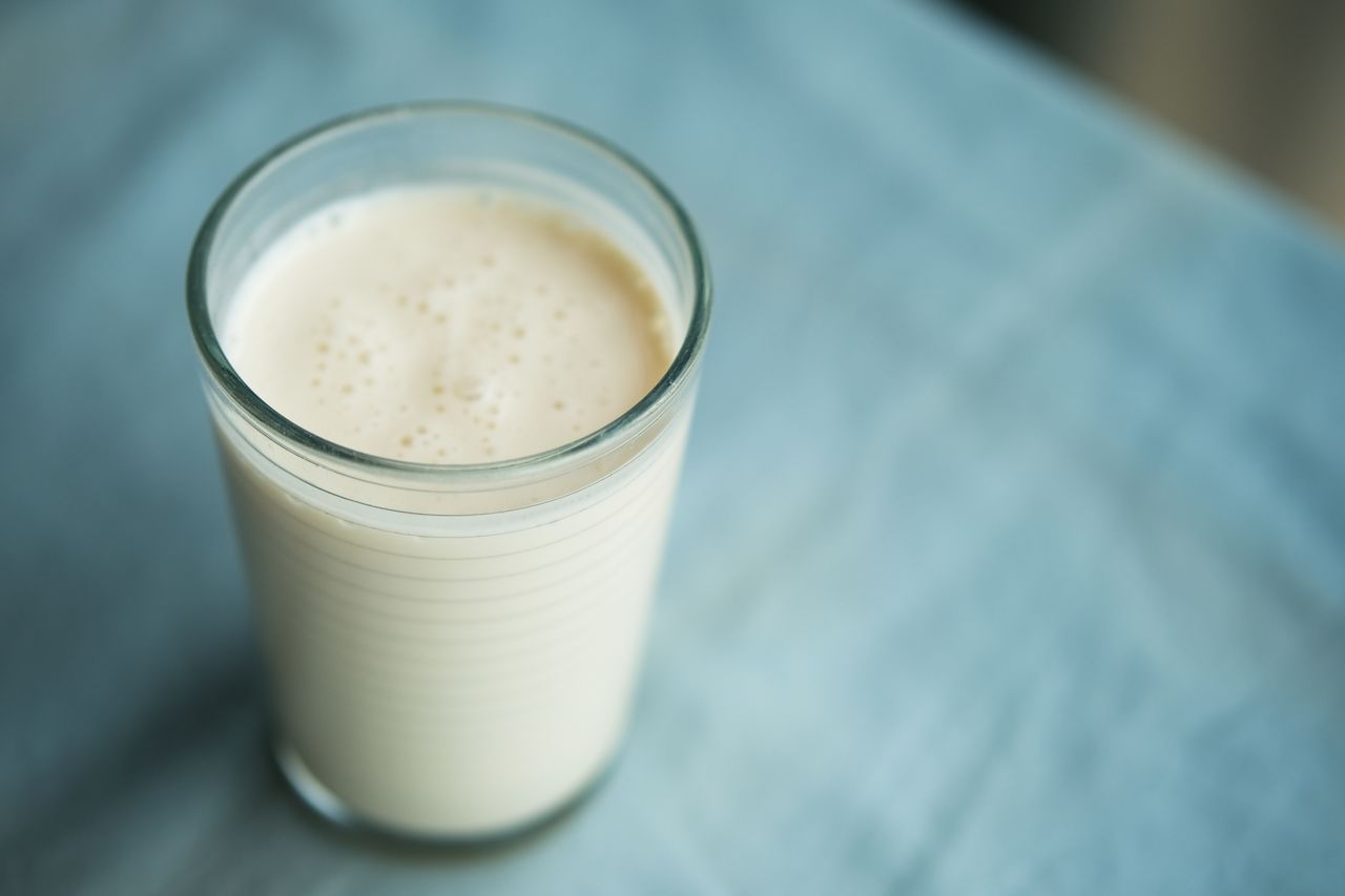 A glass of kefir on a blue surface