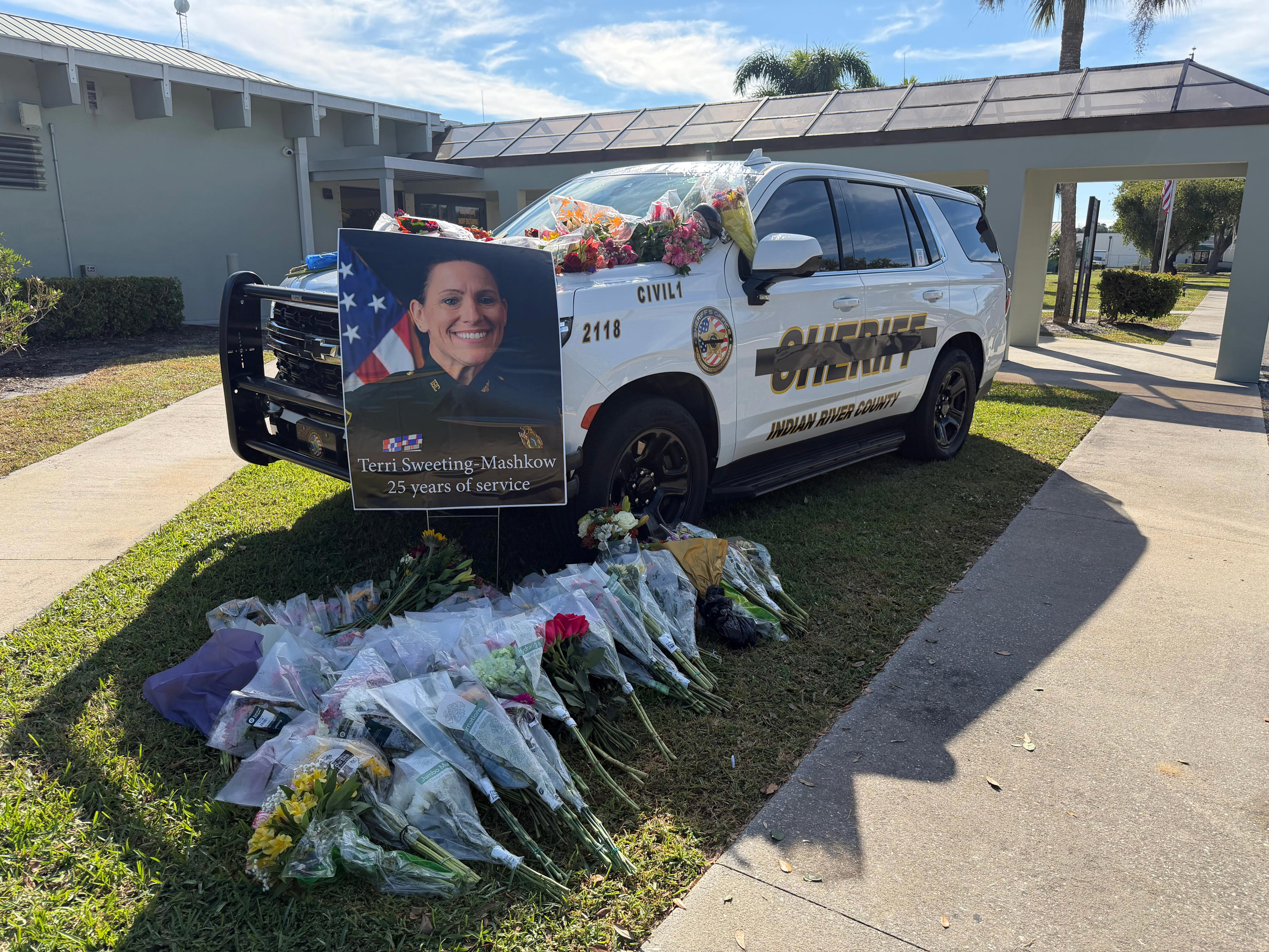 Community pays tribute to fallen deputy with flowers on patrol vehicle