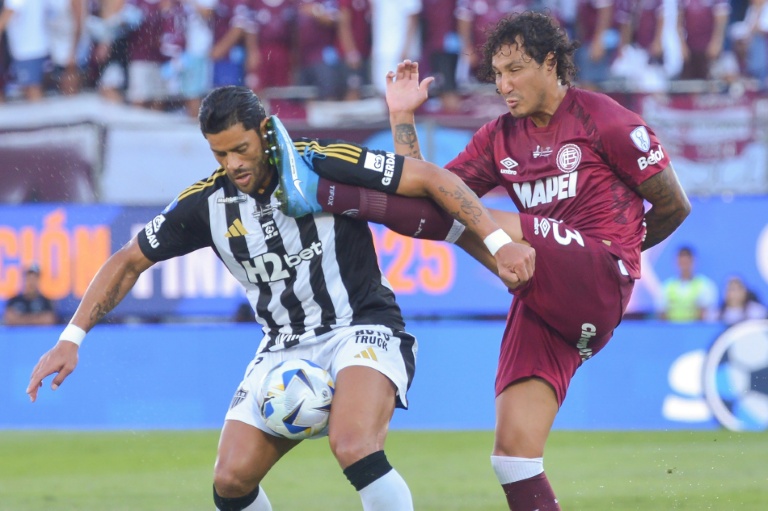 O atacante do Atlético-MG, Hulk, e o zagueiro do Lanús, José Maria Canale, disputam a bola.