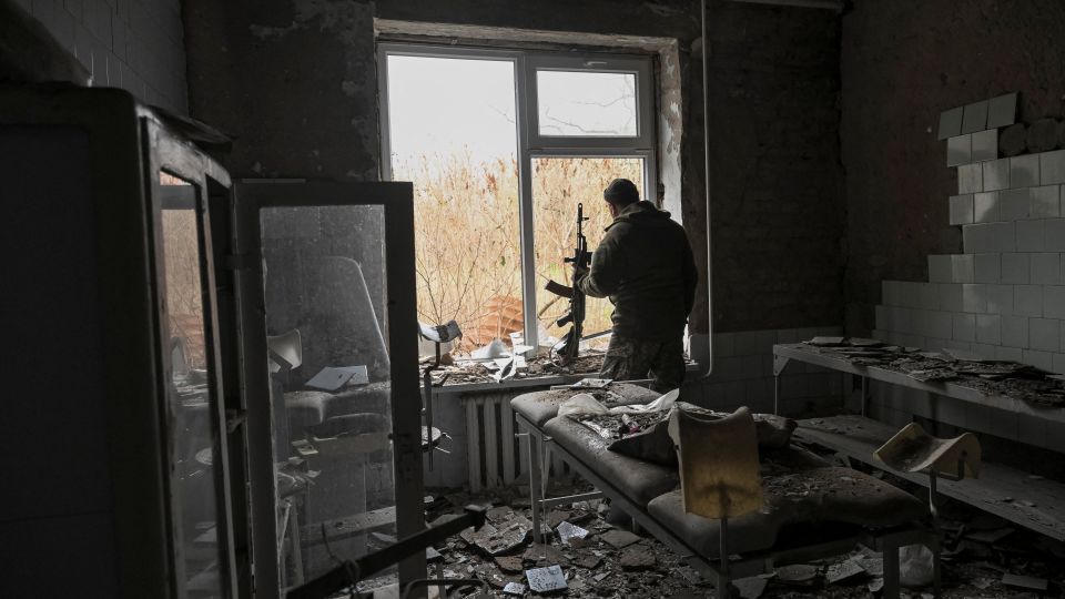A Ukrainian serviceman watches from a hospital damaged by Russian strikes in the frontline town of Orikhiv in Zaporizhzhia region, Ukraine, on November 13. - Stringer/Reuters