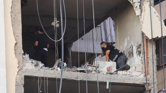 People inspect a damaged building after the strike. Pic: Reuters
