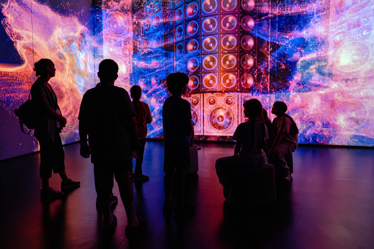 Adults and children watching an exhibit at the Griffin Museum of Science and Industry in Chicago.