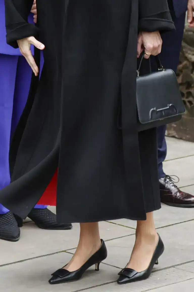 La Reina Letizia luce en China sus complementos de confianza, zapatos de tacón sensato y el bolso de Carolina Herrera que más usa. 