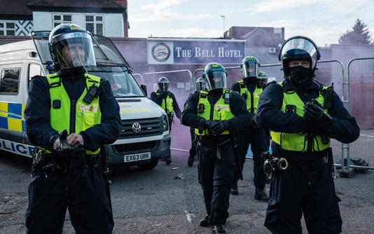 Police officers guard the Bell Hotel amid anti-immigration protests in July 2025 - Carl Court/Getty Images
