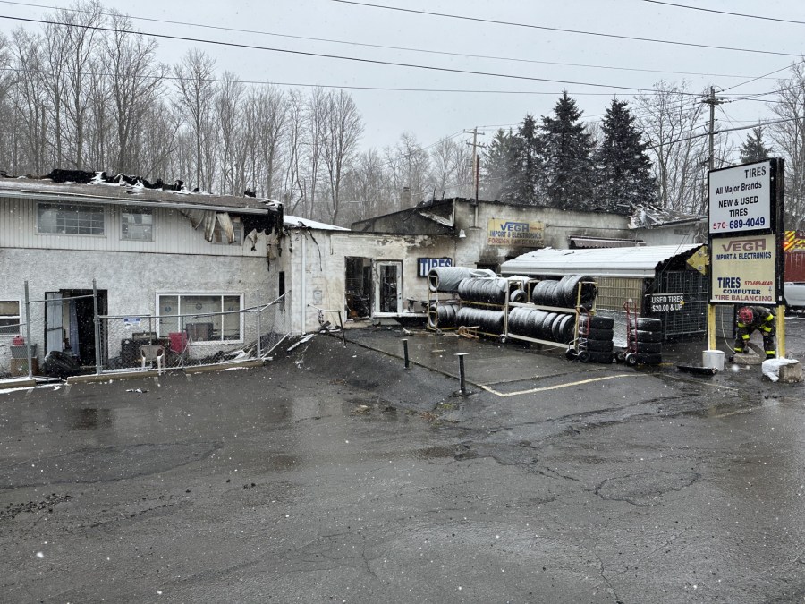 Firefighters battle blazing tire shop fire as snow falls