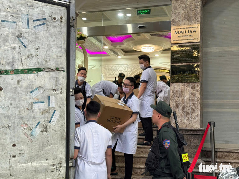 Việc bốc vác các thùng tài liệu lên xe được cảnh sát giám sát chặt chẽ - Ảnh: DANH TRỌNG
