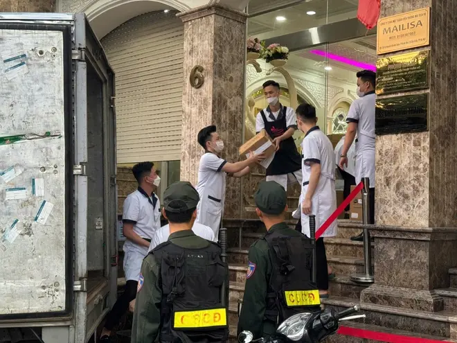 Hình ảnh cảnh sát đưa hàng trăm thùng giấy tại Thẩm mỹ viện Mailisa lên xe tải
