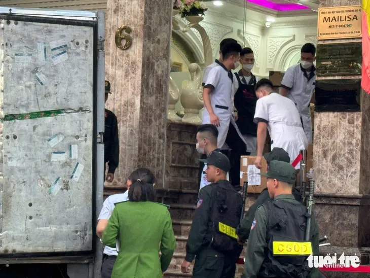 Hình ảnh cảnh sát đưa hàng trăm thùng giấy tại Thẩm mỹ viện Mailisa lên xe tải