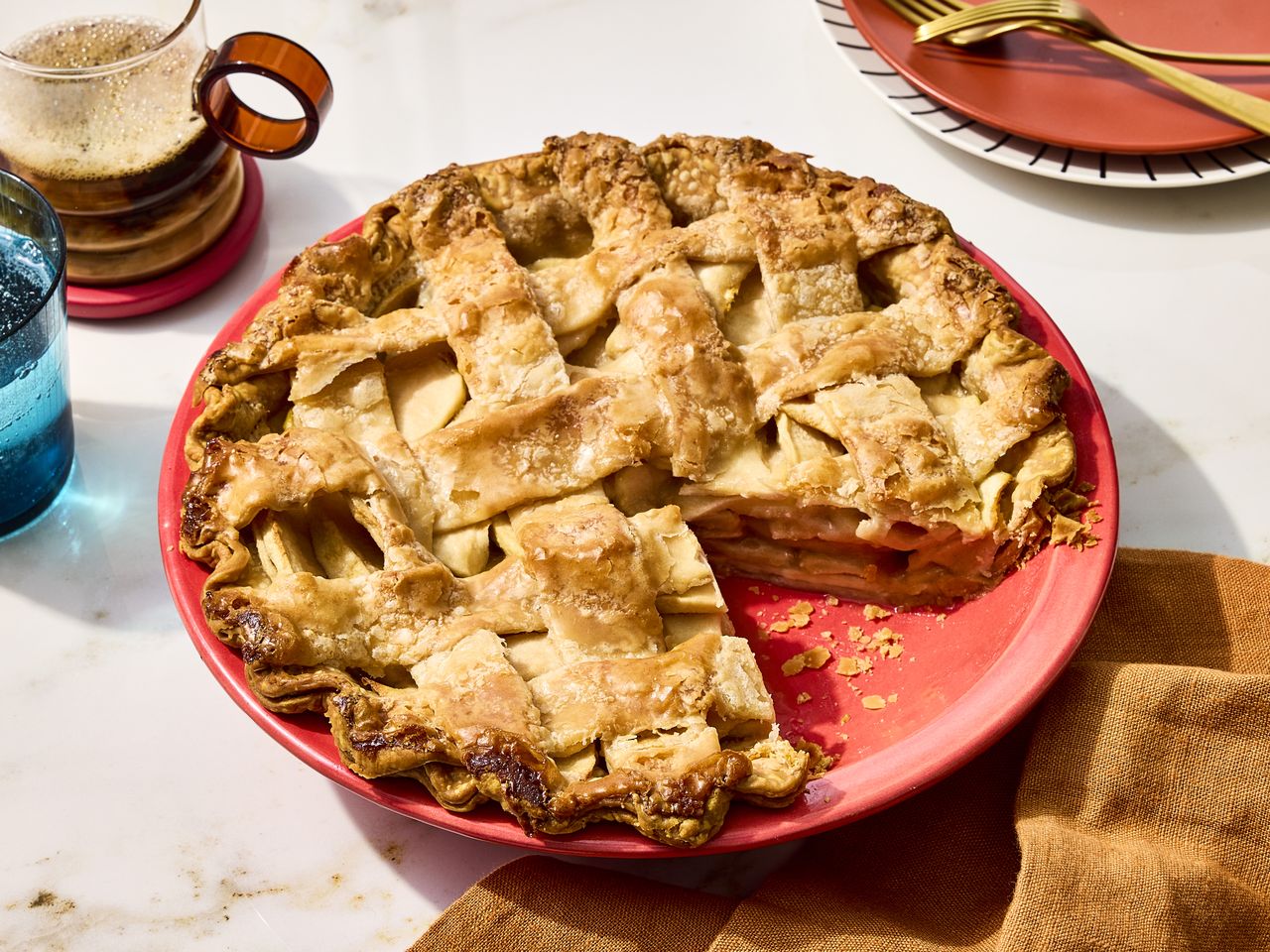 Apple pie in a red pie pan.