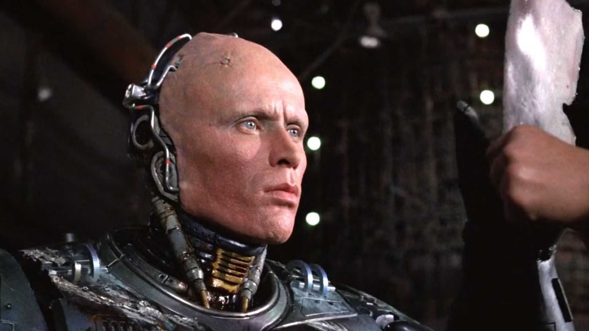 RoboCop (Peter Weller) removes his helmet to look at Alex Murphy's reflection in RoboCop