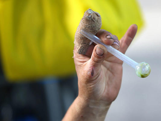  A woman holds a pipe she uses to smoke fentanyl, in downtown Calgary.