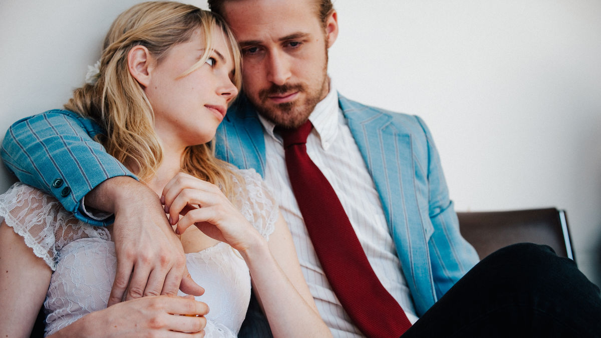 A couple sit with their arms around each other in