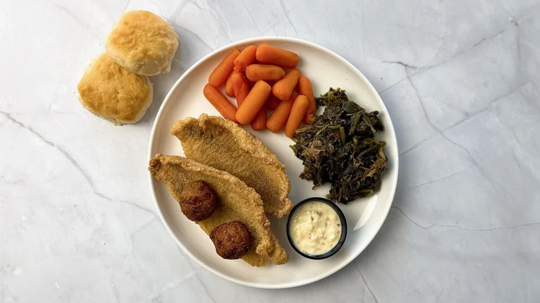 Fried catfish dish on a plate with carrots and greens