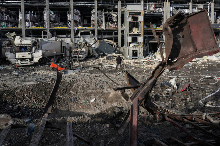 Oleksii Filippov/AFP via Getty Images - PHOTO: Employees work next to a crater at the site of the heavily damaged logistics hub of the Novus supermarket following Russian missiles and drones strikes in Kyiv, November 25, 2025.