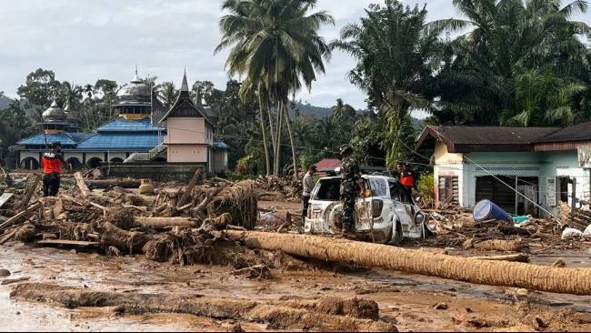 Tim penyelamat mencari korban di sebuah desa yang terdampak banjir bandang di Kabupaten Agam, Sumatera Barat (Sumbar), Minggu (30/11/2025).
