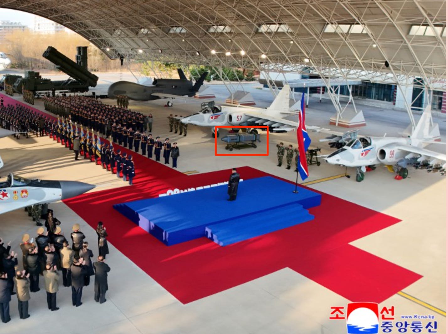 Kim Jong Un stands on a stage facing a range of air force assets.