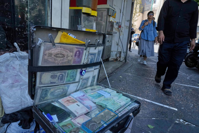 Current and pre-revolution Iranian banknotes are displayed by a street money exchanger (Copyright 2025 The Associated Press. All rights reserved)