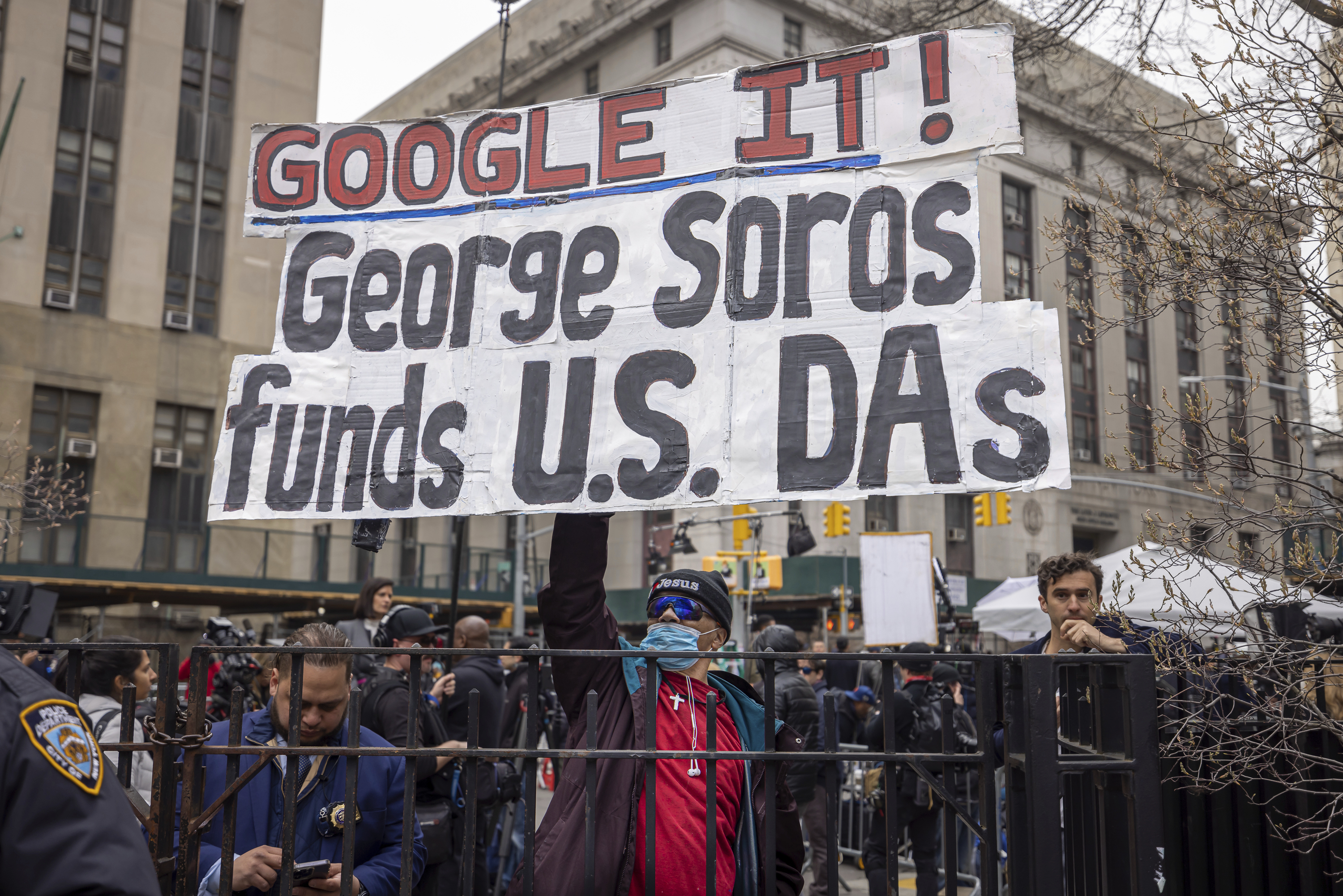 A demonstrator with an anti-Soros sign outside a New York courthouse ahead of Donald Trump's arraignment on April 4, 2023.