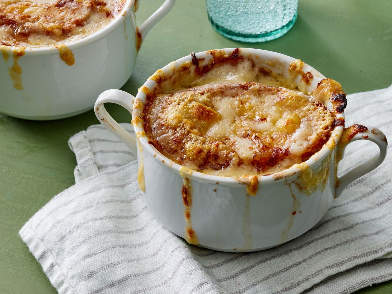 A crock of slow cooker French onion soup, topped with melted cheese